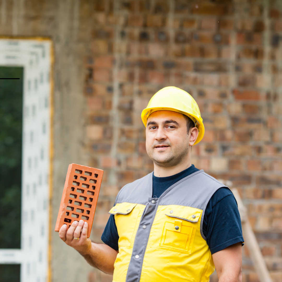 Man holding a brick in the construction materials supply chain.